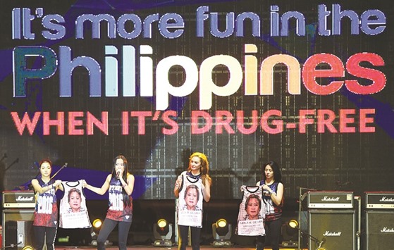 Mocha Uson (second left), a blogger and supporter of  President Rodrigo Duterte, onstage with her colleagues displaying T-shirts decorated with a mugshot of arrested legislator Senator Leila De Lima during a pro-Duterte rally at a park in Manila, coinciding with the u201cPeople Poweru201d revolution anniversary.