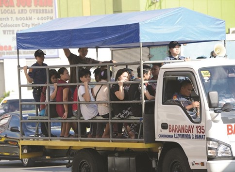  Policemen ride on a village truck ferrying stranded passengers in Caloocan City of suburban Manila yesterday, as jeepney drivers staged a nationwide transport strike.