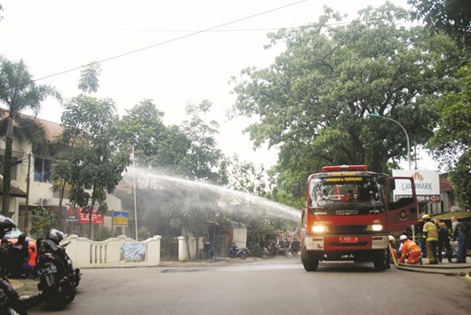 Indonesian police use a water cannon during a firefight at a government office yesterday in Bandung, after a small bomb was set off in a public park.