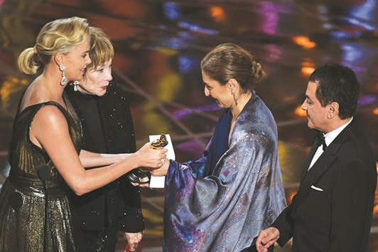 Iranian-US engineer Anousheh Ansari (second right) accepts on behalf of Iranian director Asghar Farhadi the award for Best Foreign Language Film for The Salesman from South African-US actress Charlize Theron (left) and US actress Shirley MacLaine at the 89th Oscars on Sunday in Hollywood, California.