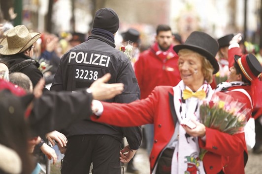 A police officer walks among revellers at the u2018Rosenmontagu2019 parade in Cologne, Germany.