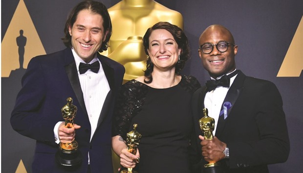 Producers Jeremy Kleiner and Adele Romanski with writer/director Barry Jenkins pose in the press room with the Oscar for Best Picture.