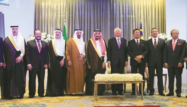 Saudi Arabiau2019s King Salman and Malaysiau2019s Prime Minister Najib Razak pose with other officials for a group photo during a deal signing ceremony between Saudi oil giant Aramco and Malaysian firm Petronas in Kuala Lumpur yesterday.