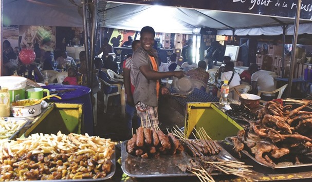 A food vendor poses for a picture during Fespaco in Ouagadougou.
