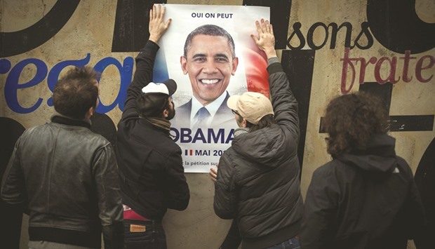 The four authors of u2018Obama 17u2019, who requested anonymity, pose in front of a poster to promote Obamau2019s candidacy to the French presidential election in 2017.