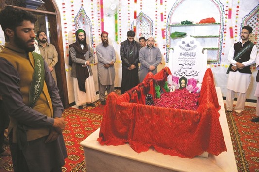 Pakistani followers stand as they pay their respects to Mumtaz Qadri, who was hanged last year for the murder of a governor who criticised Pakistanu2019s blasphemy law and defended a Christian woman, at his tomb in Bara Kahu on the outskirts of Islamabad on February 27, 2017, at the start of a three-day festival marking the anniversary of his hanging on February 29, 2016.