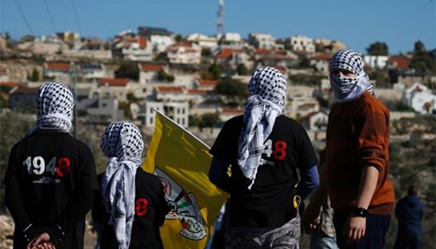 Palestinian protesters stand facing the Israeli settlement of Qadumim (Kedumim) during clashes with Israeli security forces in the occupied West Bank in this file picture.