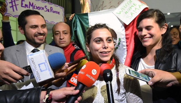 Samah Abdullhamid (C), the first Syrian refugee in Mexico, who will be helped by Mexican students to complete her studies, talks to the media on her arrival to Benito Juarez International Airport in Mexico City.