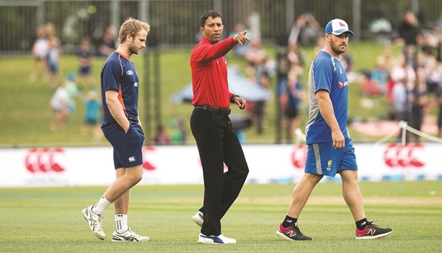 Umpire Kumar Dharmasena (centre) talks to captains Kane Williamson (left) of New Zealand and Aaron Finch of Australia after rain delayed the start of the 2nd ODI in Napier on Thursday. The match was eventually abandoned. (AFP)