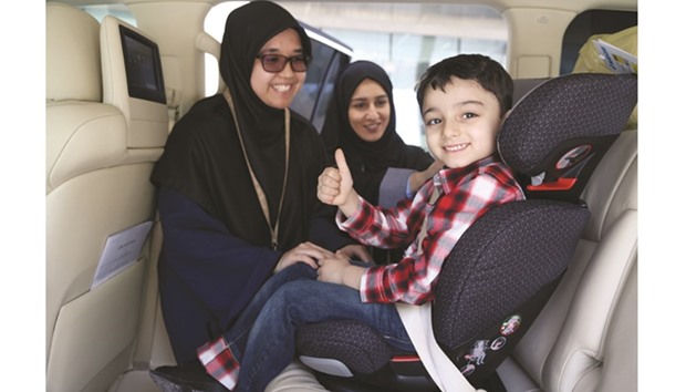 A child is fastened to a seat as part of the Sidra car seat campaign.
