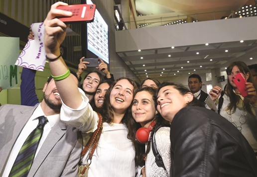 Samah Abdulhamid (centre), the first Syrian refugee in Mexico, takes a selfie picture with Mexican students who will help her to complete her studies, on her arrival at Benito Juarez International Airport in Mexico City.