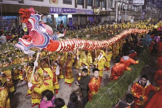 People hold a dragon lantern as they parade to celebrate the Chinese Lunar New Year in Guizhou province. Chinau2019s income from holiday tourism during the January 27 to February 2 period rose 15.9% from a year earlier to 423.3bn yuan ($62bn).