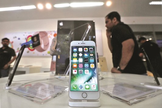 An iPhone is seen on display at a kiosk at a reseller store in Mumbai. Apple is set to begin making iPhones in India by the end of April after a prolonged negotiation over the relaxation of a rule that requires single-brand retailers to source 30% of components from within India.