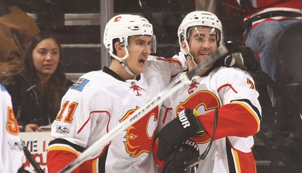 Mikael Backlund (L) and TJ Brodie of the Calgary Flames celebrate Backlundu2019s game winning overtime goal against the New Jersey Devils at the Prudential Centre in Newark, New Jersey. (Getty Images/AFP)