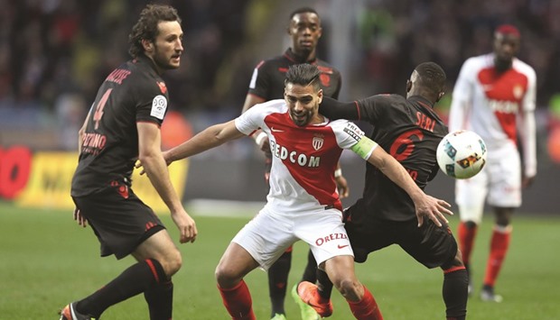 Monacou2019s Radamel Falcao (centre) vies for the ball with Niceu2019s Jean Michael Seri (right) during the French Ligue 1 match at the Louis II Stadium in Monaco yesterday. (AFP)