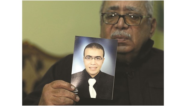 Reda El Hamahmy, the father of Abdullah El Hamahmy, holds a picture of his son during an interview with Reuters in Daqahliya, Egypt.