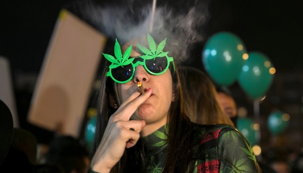 A woman smokes during an event marking Israel's government's approval of a new policy to decriminalize personal marijuana use in Tel Aviv, Israel.