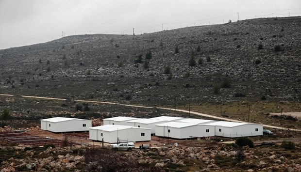 New prefabricated homes are seen under construction in the West Bank between the Israeli outpost of Amona (background) and the Israeli settlement of Ofra, north of Ramallah, on January 31, 2017.