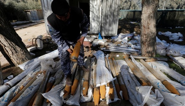 An Iraqi federal police officer inspects weapons that were used by Islamic State militants in Mosul, Iraq.