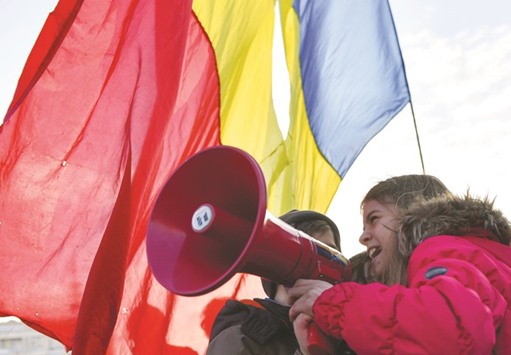 Children shout into a megaphone as the adults protest in front of the government headquarters in Bucharest against corruption in the government.