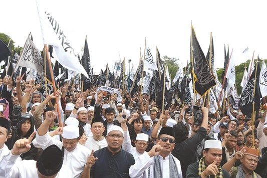 Protesters hold a demonstration against criminalisation of clerics at the National Monument in Jakarta.