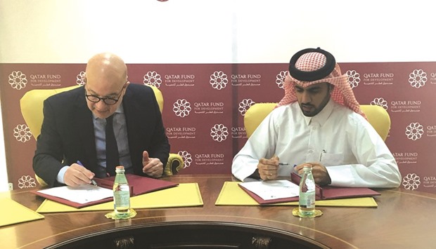 Khalifa bin Jassim al-Kuwari and Hani Qattan signing an agreement.