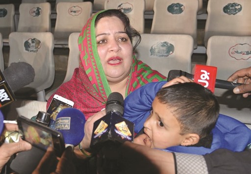 Pakistani mother Rohina Kiani holds her son Iftikhar Ahmed after he was handed over by an official as she speaks with media representatives at the Wagah border with India.