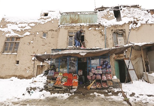 An Afghan man removes snow from his shop during a snowfall in Kabul, Afghanistan yesterdsay..