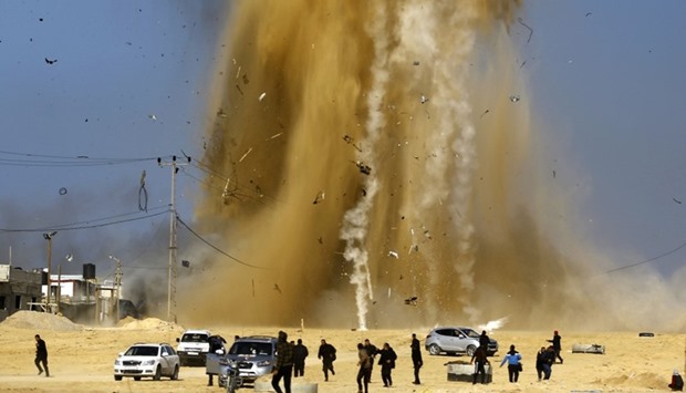 Palestinians run for cover as smoke rises following an Israeli air strike on a Hamas post, in the northern Gaza Strip.