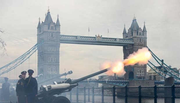 Members of the Honourable Artillery Company fire a 62-round royal gun salute from the Gun Wharf outside the Tower of London with Tower Bridge seen in the background to mark the anniversary of Queen Elizabeth II\'s accession to the throne in London on Monday.