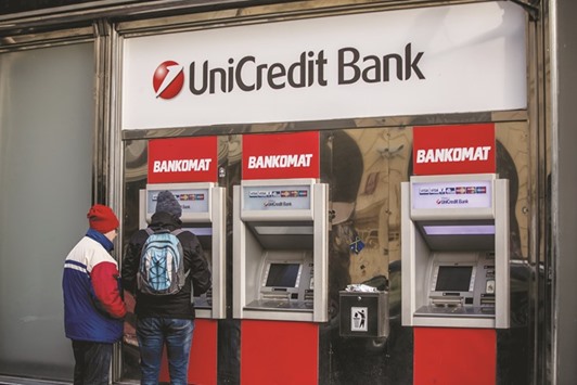 Customers use a UniCredit ATM in central Prague, Czech Republic. UniCredit is offering 13 new shares u2014 at a price of u20ac8.09 each u2014 every five ordinary or savings shares already owned.