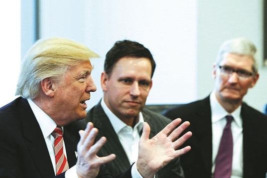 US President Donald Trump speaks as PayPal co-founder and Facebook board member Peter Thiel (centre) and Apple CEO Tim Cook look on during a meeting with technology leaders at Trump Tower in New York. The technology industry has been among the most vocal in opposition to Trumpu2019s immigration order.
