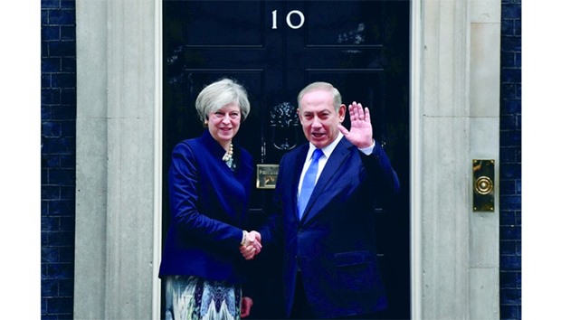 British Prime Minister Theresa May poses shaking hands with Israeli Prime Minister Benjamin Netanyahu after Netanyahu arrived for a meeting at 10 Downing Street in central London yesterday.