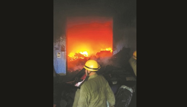 Firefighters attend to a blaze at a cloth factory in Mundka, New Delhi, yesterday.