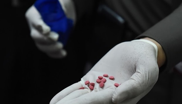 A police officer displays methamphetamine pills