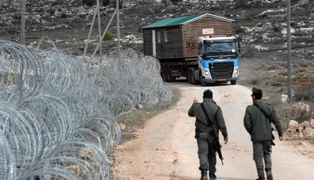 A prefabricated house is transported by a lorry after being are removed from the Israeli Amona wildcat outpost, northeast of Ramallah, in the occupied West Bank.