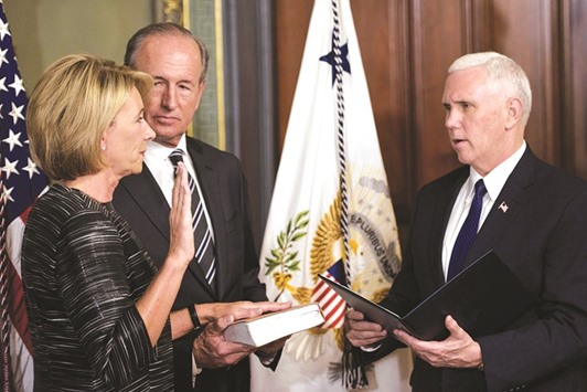 Dick DeVos watches as Vice President Mike Pence administers the oath of office to US Secretary of Education Betsy DeVos during a swearing-in ceremony in the Eisenhower Executive Office Building in Washington, DC.