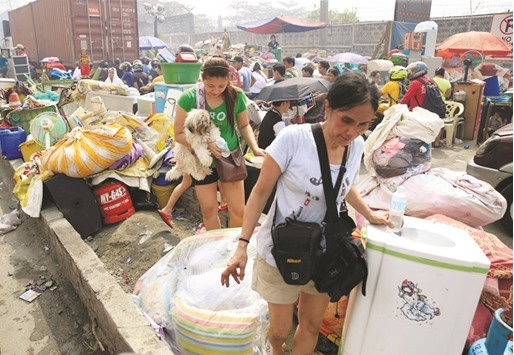 Fire victims gather along a street after a fire destroyed more than hundreds of shanties at a community of informal settlers, according to authorities, in Parola Compound, Tondo city, Metro Manila yesterday.