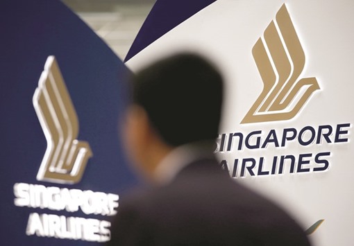A man walks past a Singapore Airlines signage at Changi Airport. The airline announced a provisional order to buy 39 Boeing wide-body planes yesterday as it battles Gulf carriers, dealing a blow to Airbus in the key market for big twinjets.