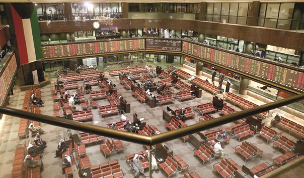 Traders follow share prices at the Kuwait Stock Exchange (KSE) in Kuwait City (file). Boursa Kuwait, as the stock exchange is known, is working with the local capital markets authority and settlement and clearing bodies to revamp its infrastructure.