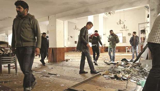 Libyans inspect the interior of a mosque in Benghazi, after it was hit with a twin bomb attack.