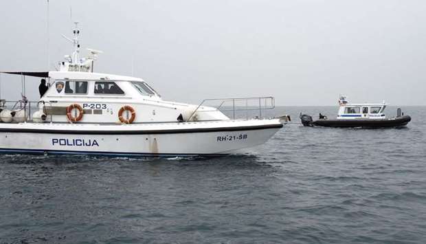A police boat patrols next to a Croatian fisherman boat off the coast of Piran.