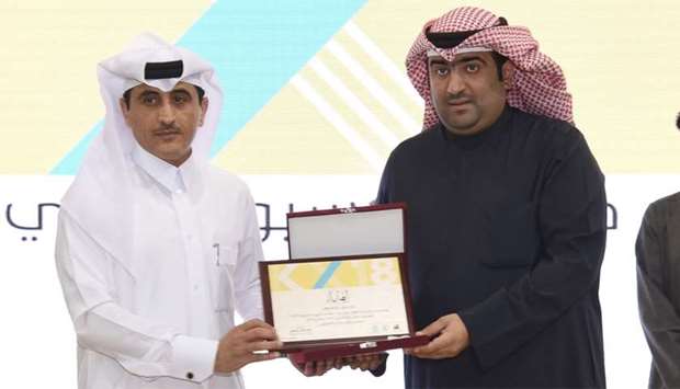 Kuwait's Minister of Commerce and Industry Khaled Nasser al-Roudan handing over the award to director of business development at Qatar's Ministry of Economy and Commerce (MEC), Abdulbasit al-Aaji