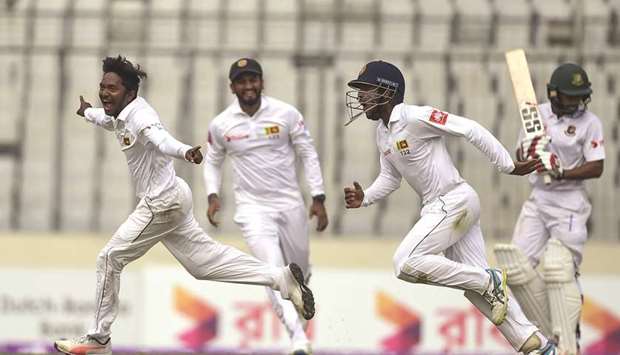 Sri Lankau2019s Akila Dananjaya (left) celebrates after taking the wicket of Bangladeshu2019s Mehidy Hasan during the third day of the second Test at the Sher-e-Bangla National Cricket Stadium in Dhaka yesterday. (AFP)
