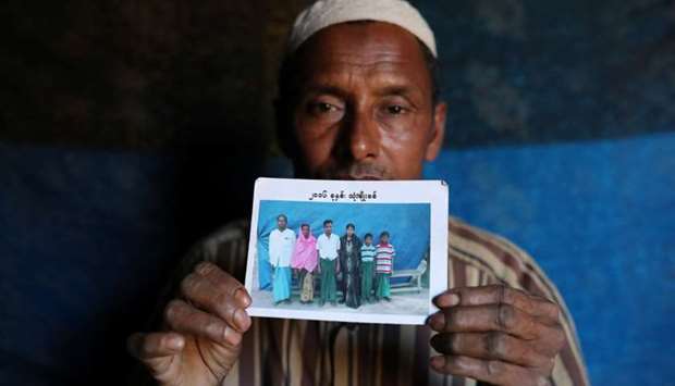 Abdu Shakur, whose son Rashid Ahmed was among 10 Rohingya men killed by Myanmar security forces and Buddhist villagers on September 2, 2017, holds a family picture at Kutupalong camp in Cox's Bazar, Bangladesh.