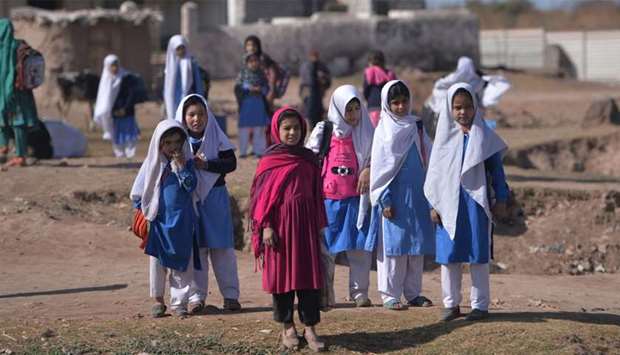 Afghan refugee girls leave after their school at a refugee camp on the outskirts of Islamabad