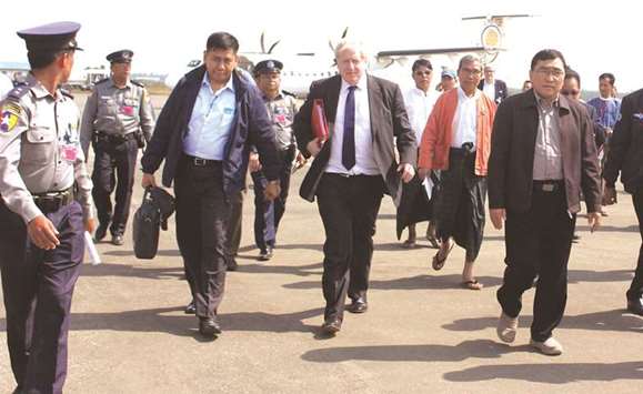 Britainu2019s Foreign Minister Boris Johnson (centre) arrives at the airport in Sittwe, the capital of Rakhine state, accompanied by local officials and police yesterday.