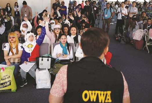 Filipino workers who were repatriated from Kuwait take part in a dialogue with a Department of Labour official at Ninoy Aquino International Airport in Paranaque, Metro Manila, yesterday.