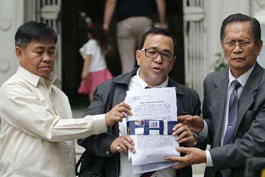 Lawyers Nasser Maromsalic, Manuelito Luna and Eligio Mallari show a copy of the complaint they filed at the Department of Justice against former president Benigno Aquino and other former government officials.