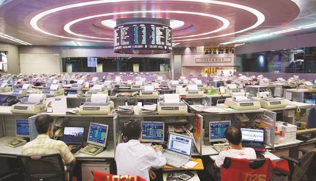 Traders work at the Hong Kong Stock Exchange. The Hang Seng closed down 0.2% to 29,459.63 points yesterday.
